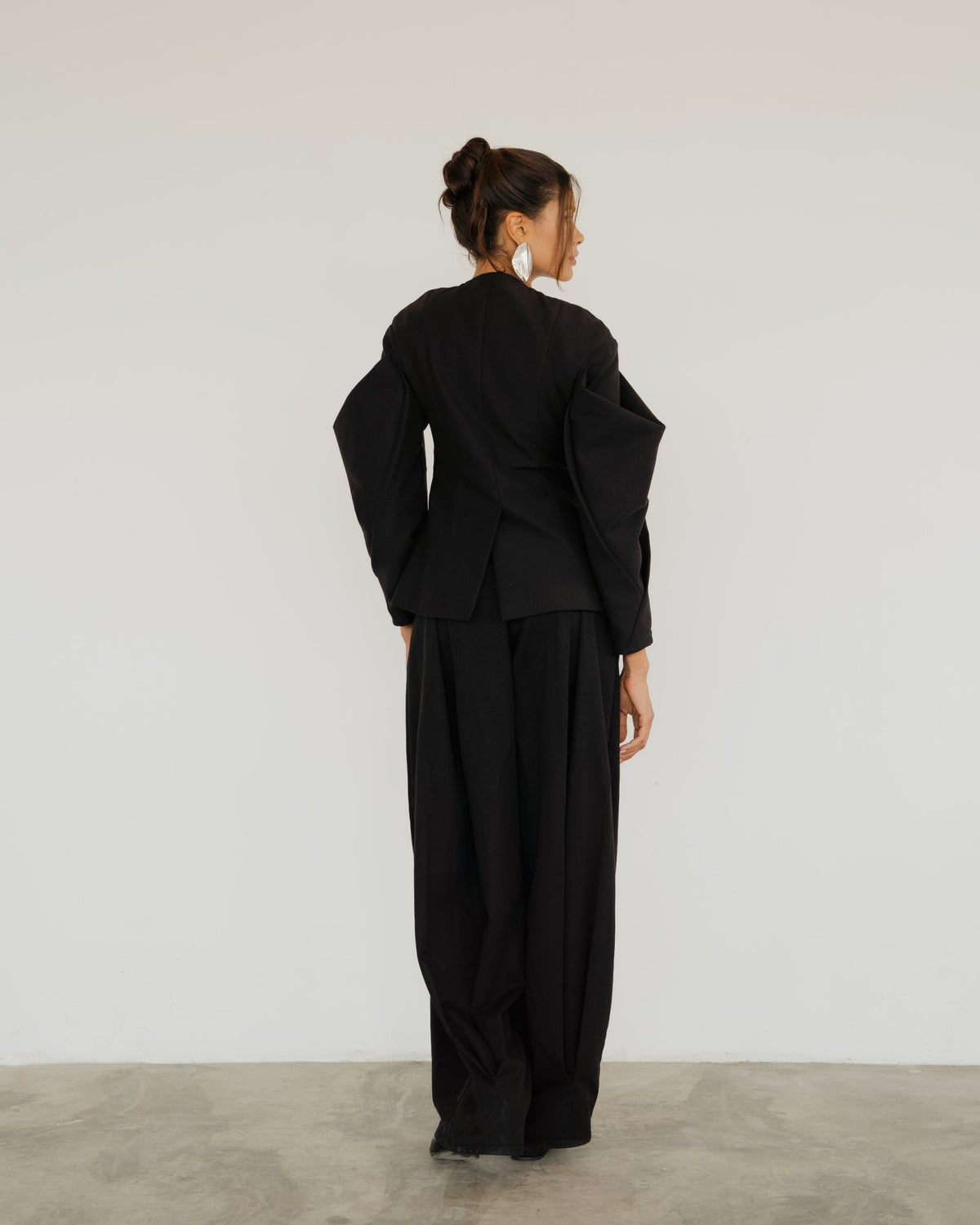 Model wearing the Nara Pants in black with the Ansra Jacket, back view