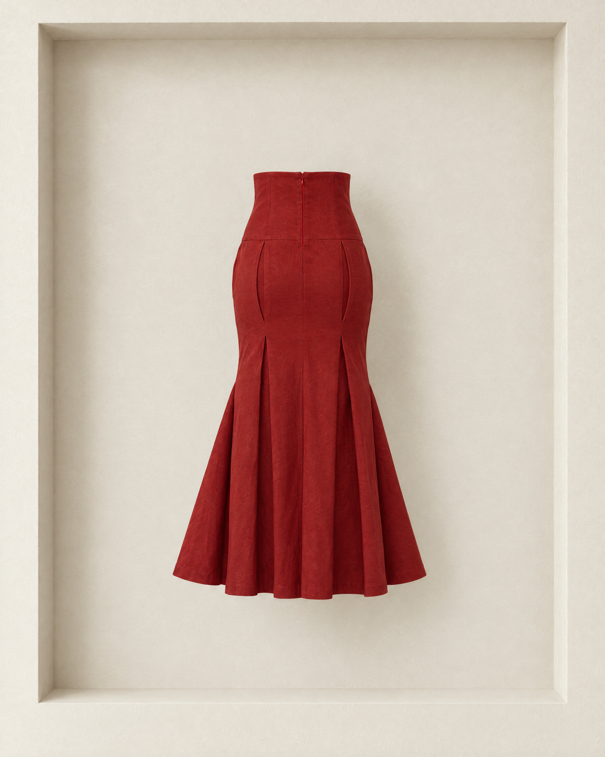 Neya Skirt in burgundy, back view — centre-back zip, curved pleats and trumpet flare